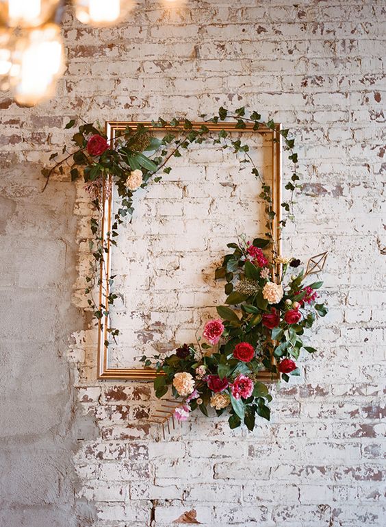 a vintage picture frame decorated with greenery and blooms will be a nice artwork for your venue