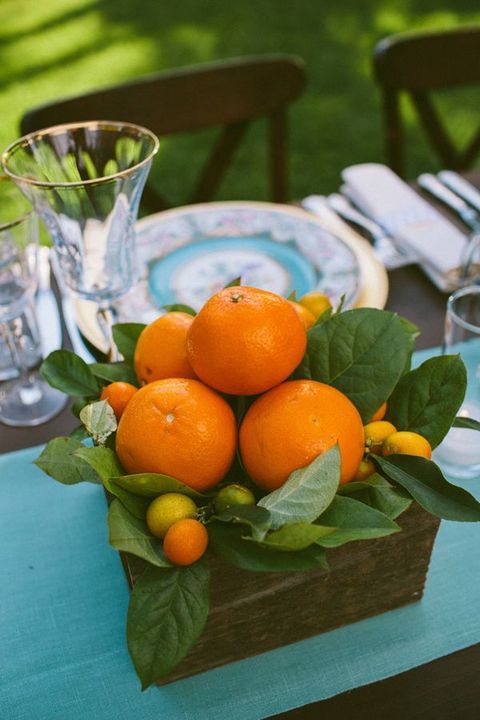 a wooden box with oranges and other citrus and foliage can become a nice and simple centerpiece
