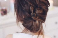 16 a casual messy braided updo with bangs and a small hairpiece to accentuate it