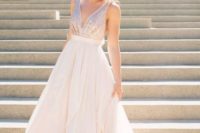 16 a sleeveless blush wedding gown with a sequin bodice and a plain full skirt, a plunging neckline