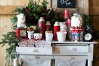17 a gorgeous hot chocolate bar with an evergreen garland, plaid thermoses, lots of sweets for eating them