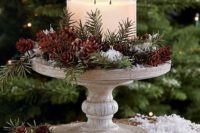 18 a winter wedding centerpiece with evergreens, pinecones, faux snow and a large double candle