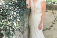 18 an ivory wedding dress with cap sleeves, an illusion plunging neckline and a lace skirt