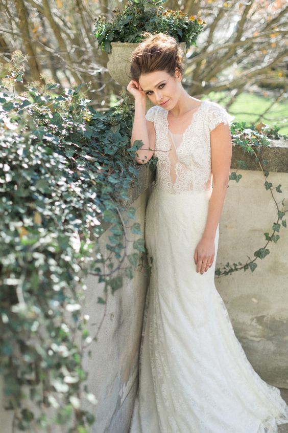 an ivory wedding dress with cap sleeves, an illusion plunging neckline and a lace skirt