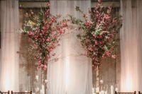 19 a draped fabric backdrop, lots of candles in candle holders and lush pink blooms in vases