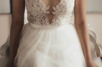 19 an illusion plunging neckline sleeveless wedding dress with a lace applique bodice and a tulle skirt