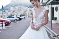 20 A-line wedding dress with cap sleeves, a boho lace bodice with an illusion plunging neckline and a textural skirt