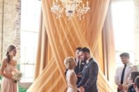 20 a draped fabric backdrop and a glam chandelier for a refined look