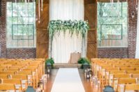 21 a draped fabric backdrop, a lush greenery and white bloom arch and greenery chandeliers hanging over it