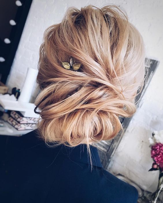 a casual twisted updo with a double chignon and a rhinestone hairpiece for an accent