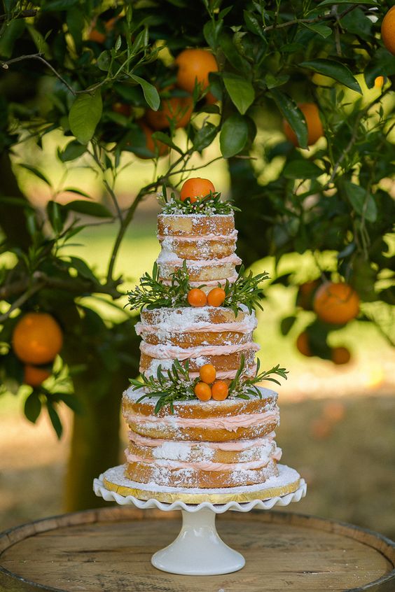 a naked wedding cake with greenery and fresh lumquats is great for a summer wedding