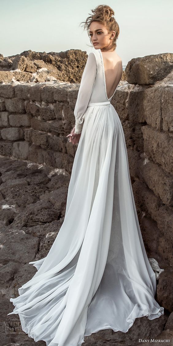 a sleek wedding dress with long sleeves, an open back and a train for a modern bride