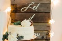 25 a white frosted wedding cake topped with blooms, pinecones and fir branches