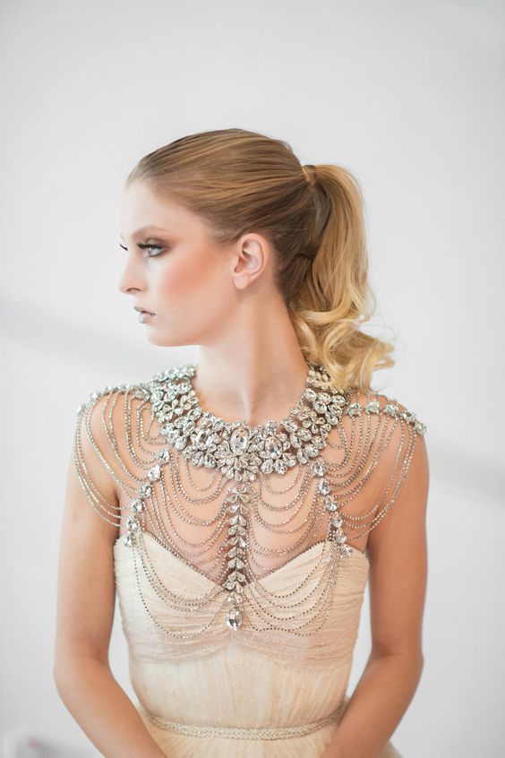 a statement bridal shoulder jewelry piece with lots of rows of beads and large rhinestones for a parkly bridal look