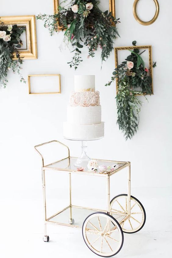 accentuate your wedding cake table with vintage frames and greenery and flowers attached to them