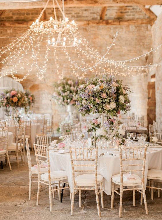 a beautiful canopy of lights for a barn wedding looks chic and brings enough light