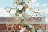 03 a geometric backdrop of wooden hexagons, bulbs and lush greenery and blooms