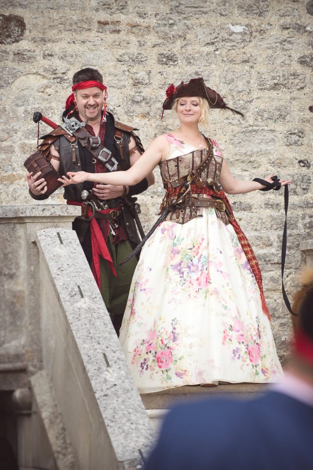 The bride was wearing a floral wedding dress and some pirate accessories, and the groom was dressed as a pirate