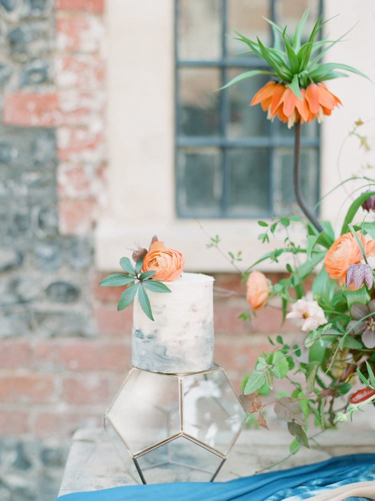 The second wedding cake was a watercolor one topped with a bloom and greenery and served on a geometric stand