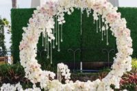 08 a luxurious circle floral arch with white and pink blooms and hanging crystals plus petals all around