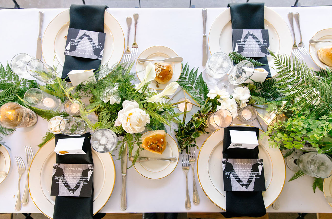 The wedidng tablescape was done in black, white and gold and with lots of greenery
