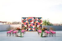 10 a colorful geometric backdrop with a mid-century modern feel and matching pink chairs