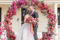10 a super bold circle wedding arch with fuchsia, pink, orange blooms and citrus for a southern wedding