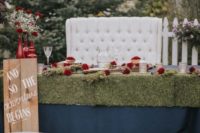 11 The wedding tables were covered with moss, with red blooms, baby’s breath and wooden touches to give it a rustic feel