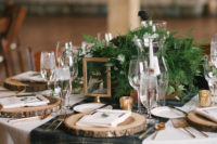 12 Wood slice chargers with greenery and some gilded touches made the tablescapes cozy