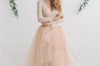 12 a champagne-colored wedding dress with a lace bodice, a deep V-neckline, long sleeves and a layered skirt