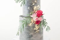 12 a concrete wedding cake with gold leaf and bold blooms and greenery looks very modern