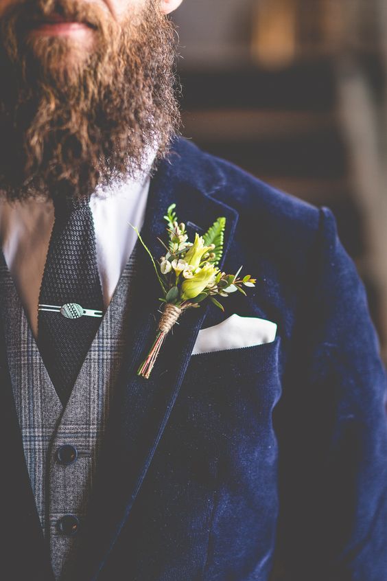 a hipster groom look with a navy velvet jacket, a tweed vest, a white shirt and a black tie