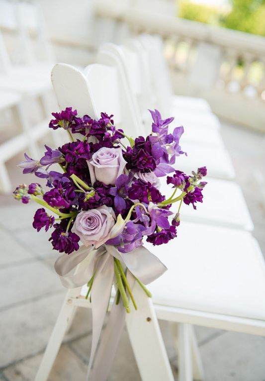 decorate the aisle chairs with gorgeous bouquets with violet and lilac blooms with a grey ribbon bow