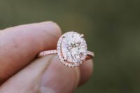 15 a rose gold engagement ring with an oval-shaped diamond and a halo around