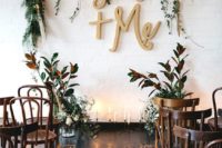 15 the ceremony space is done with greenery and white blooms, calligraphy letters and candles