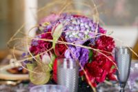 16 a bold bloom centerpiece in red and ultra violet with gold branches for an eye-catchy dimensional look