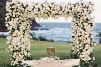 17 a floral arbor covered with white roses completely and a backdrop of the ocean look wow