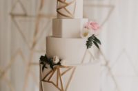 17 a white wedding cake with geometric layers and gold geometric details