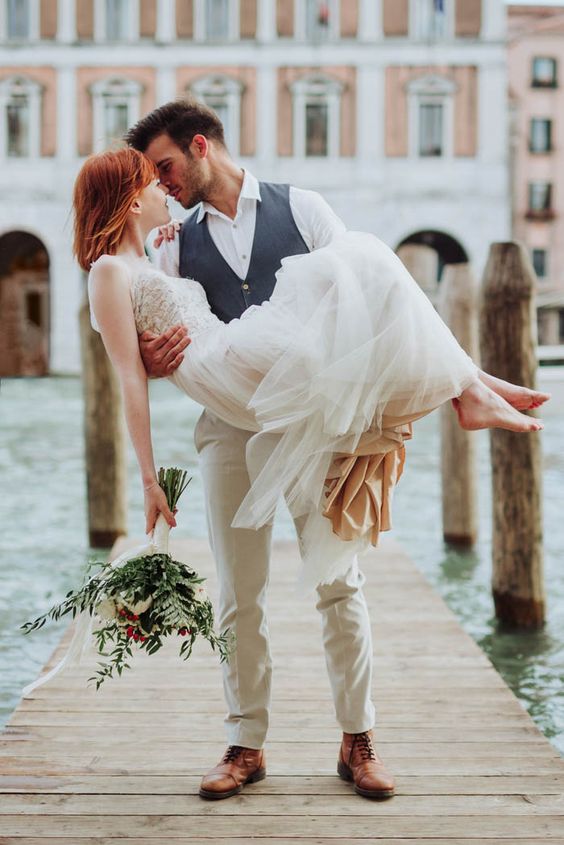 a romantic wedding dress with a flowy layered skirt and a boho lace bodice, no sleeves for a Venice elopement