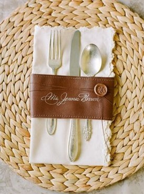 a leather cutlery and napkin ring with a seal and a wicker charger for a chic look