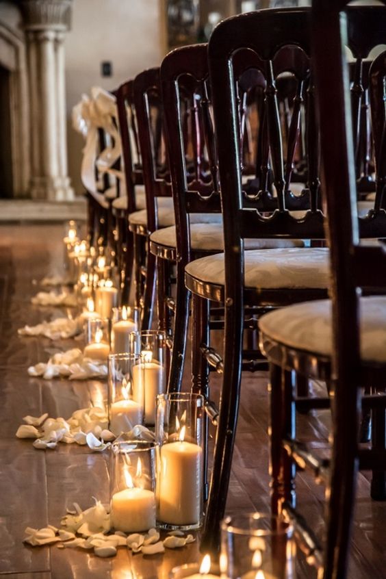 candles in tall vases and petals are a timeless idea for lining the aisle and they will fit most of wedding styles