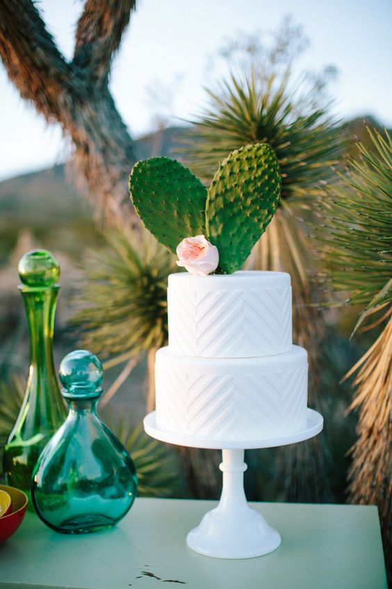 a white textural chevron wedding cake with two large cacti for a boho desert wedding