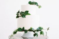 24 a modern white wedding cake with fresh foliage for a cool and bold look