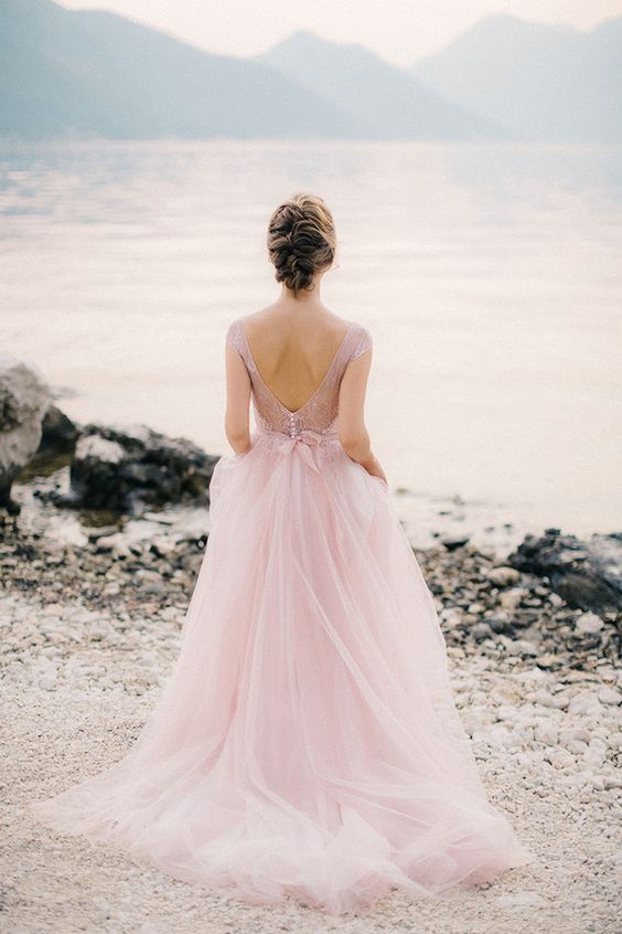 a pink wedding gown with a lace applique bodice, cap sleeves, an open back and a layered skirt