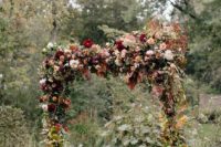 24 a super lush floral wedding arch in burgundy and pink shades, with lots of fall leaves to embrace the season