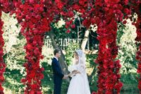 25 a super lush red floral arch can be seen from a distance and sets the tone to the wedding