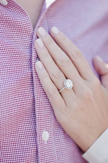 a classic round-shaped diamond ring with a thin halo and a thin band in white gold