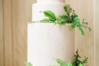 26 a white frosted wedding cake with lush greenery is all you need for a modern touch