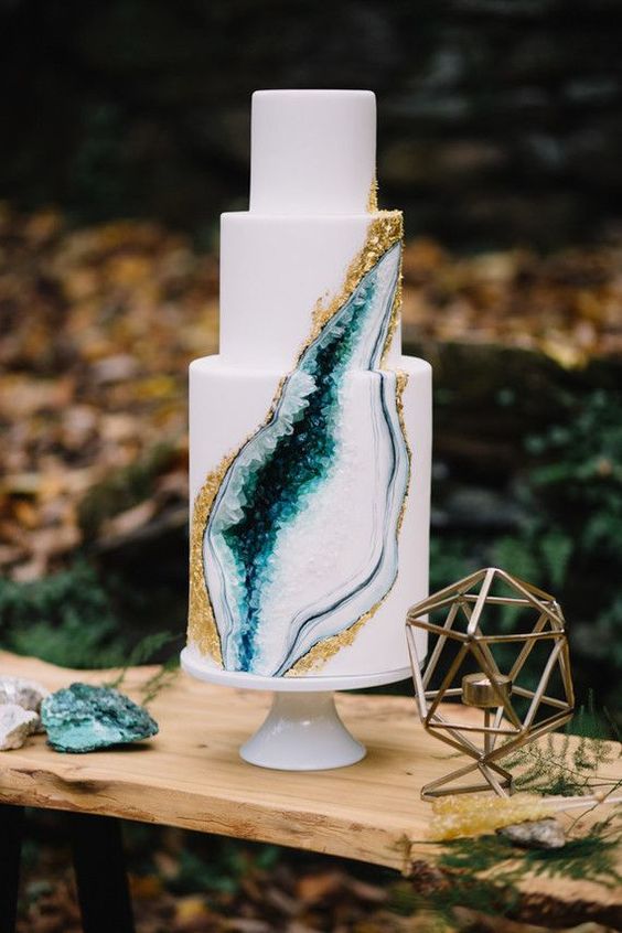 a trendy wedding cake with a gold edge and emerald crystals inside