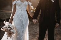 a beautiful and chic off the shoulder mermaid wedding dress with lace applique and a train is adorable for a modern glam bride